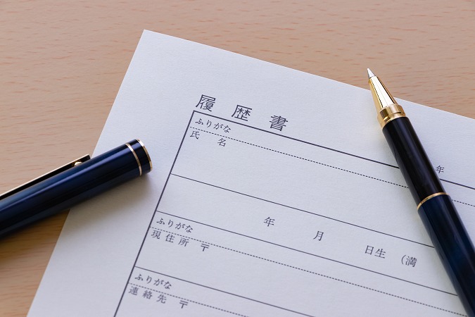 ふたが外れた黒ペンと履歴書