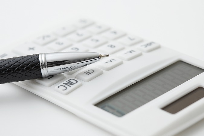 白い電卓とペン